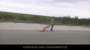Slim blonde slave leashed and whipped on the beach